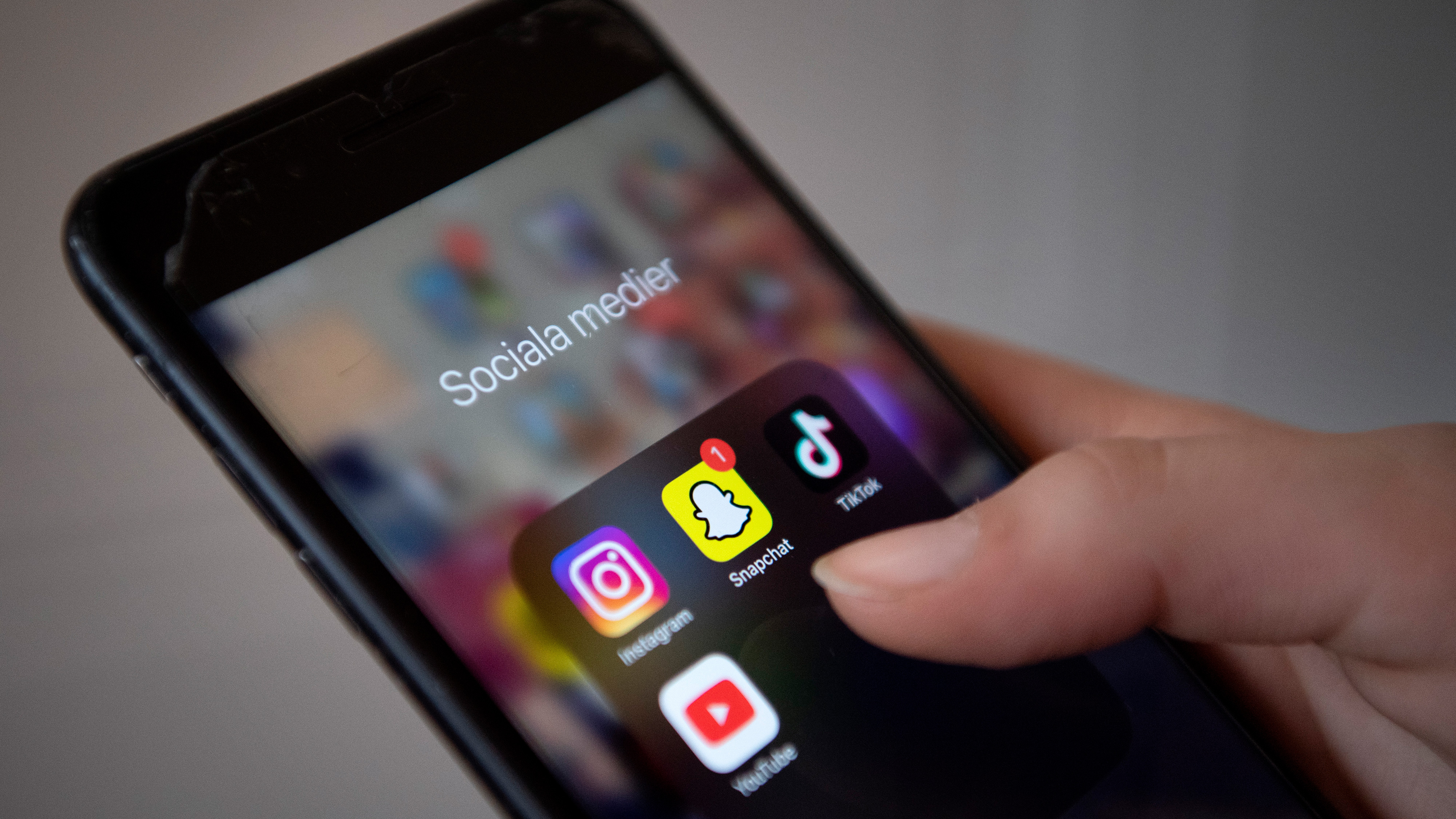Håll telefonen i handen så ser du en mapp med text "sociala medier" Innehåller även ikoner för Snapchat, TikTok och YouTube.