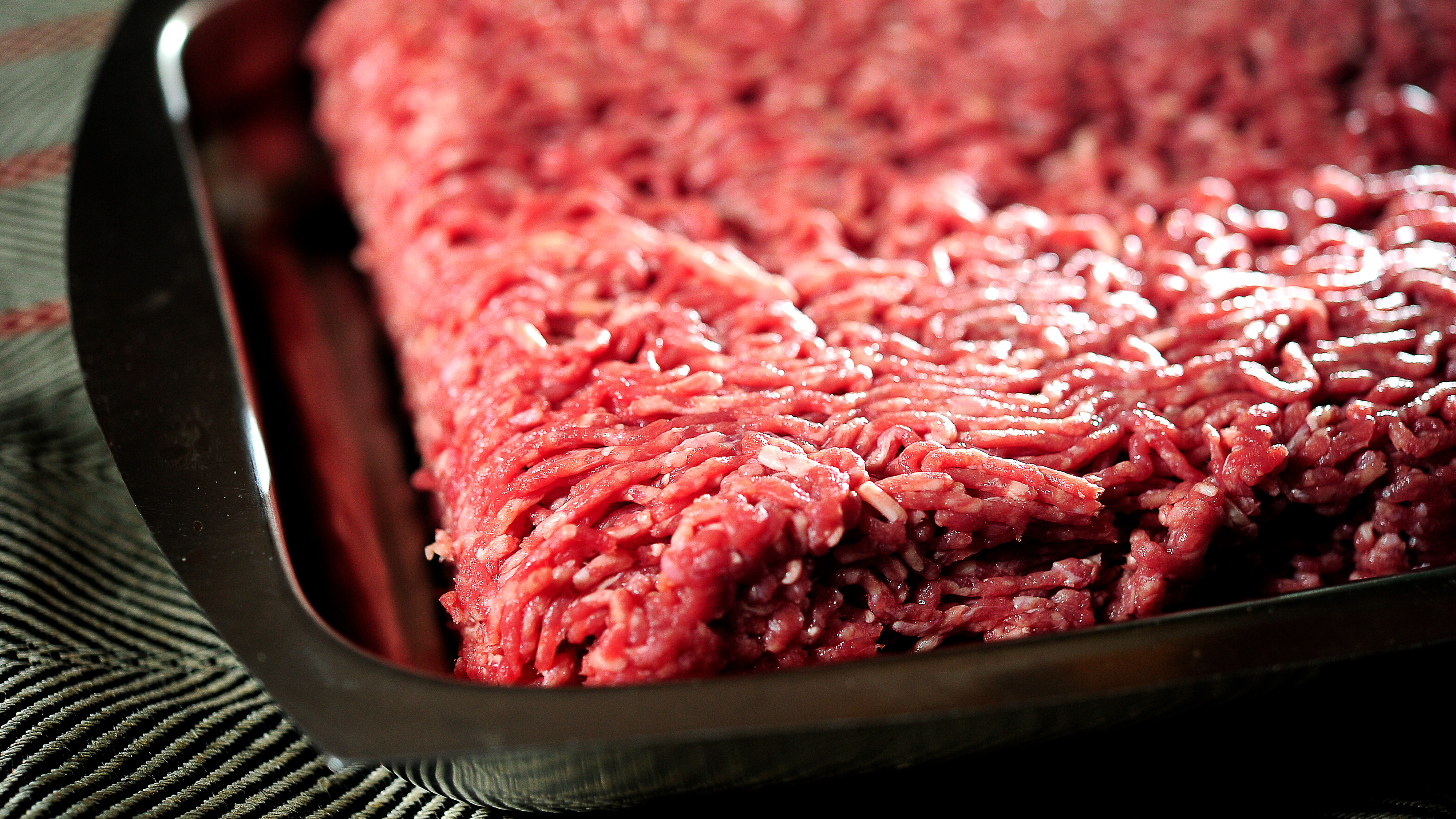 Rå köttfärs utbredd i ett metalltråg.