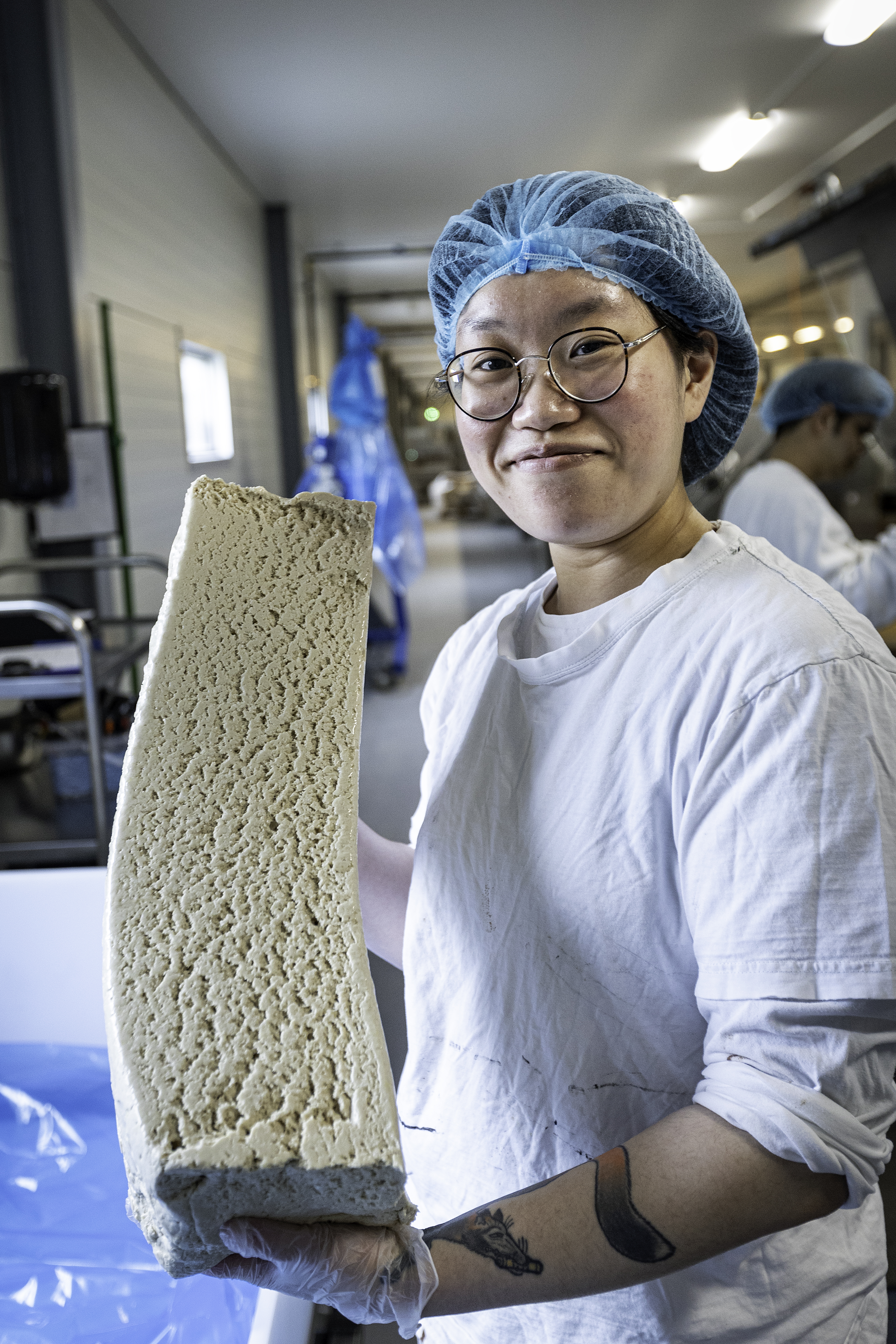 Jieying Ni i arbetskläder, hållandes material.