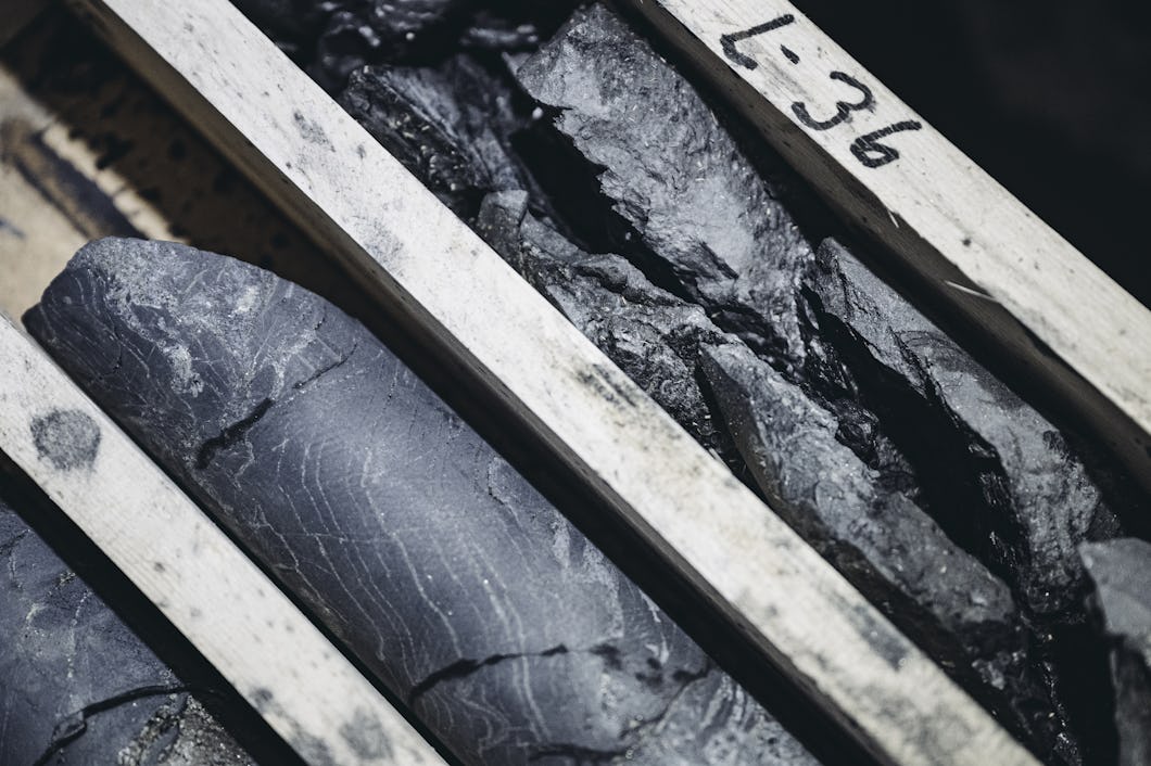 Närbild av borrkärnor placerade i en trälåda med etiketten "L-36", där materialets textur och skiktning syns.