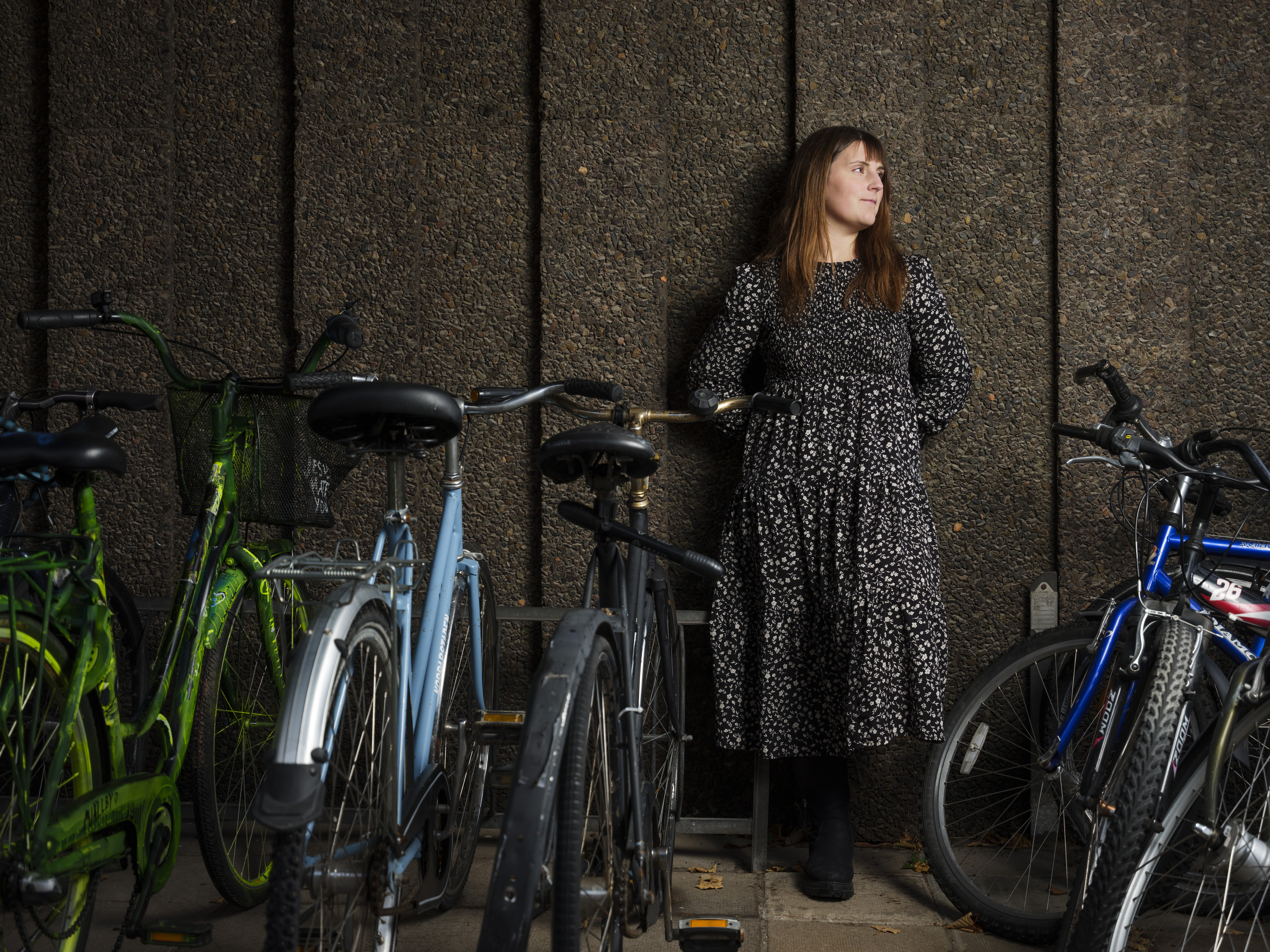 Joanna Rosenblad framför en fasad där cyklar står parkerade.