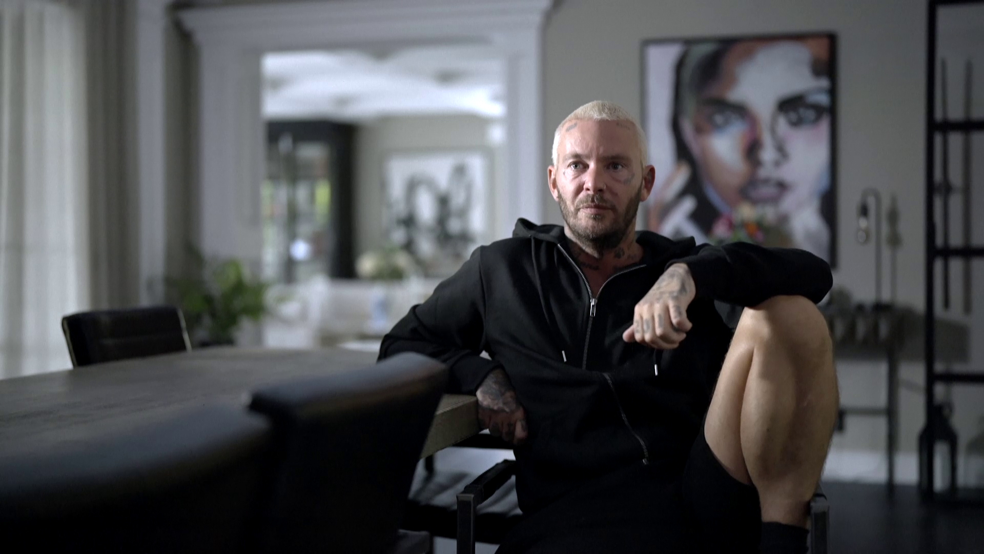 Man i vitt kort hår tittar i kameran.