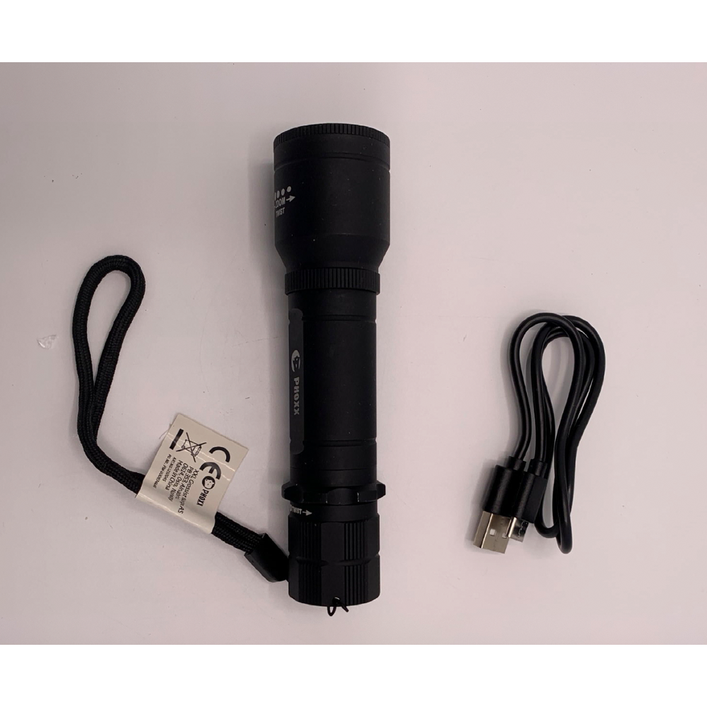En svart ficklampa med handledsrem och CE-märkning ligger intill en svart USB-laddningskabel på en vit yta.