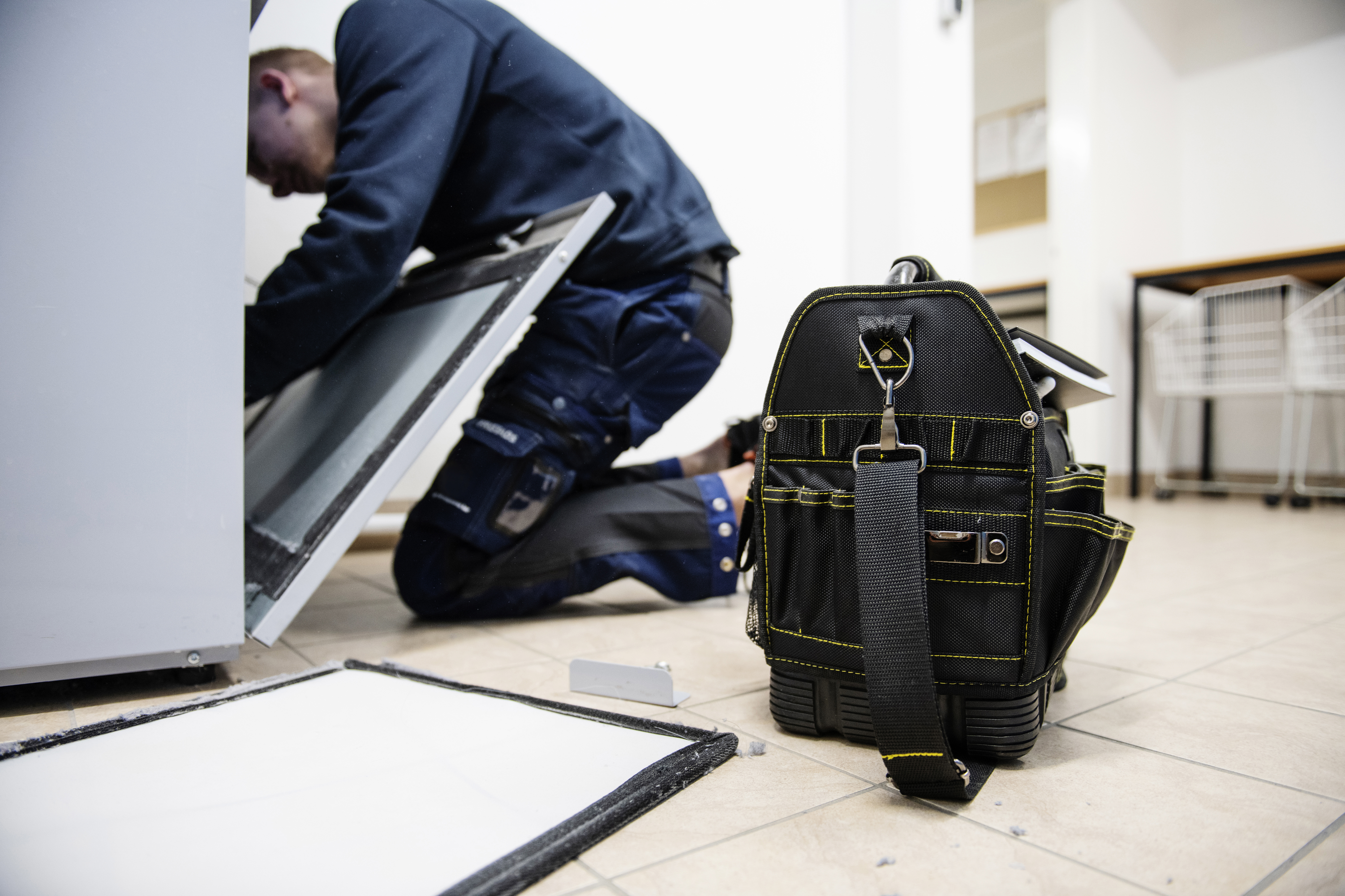 En fastighetsskötare som arbetar i en bostad.