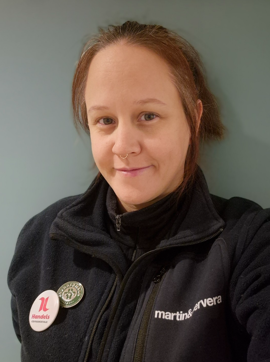 Kvinna i svart tröja tittar i kameran.