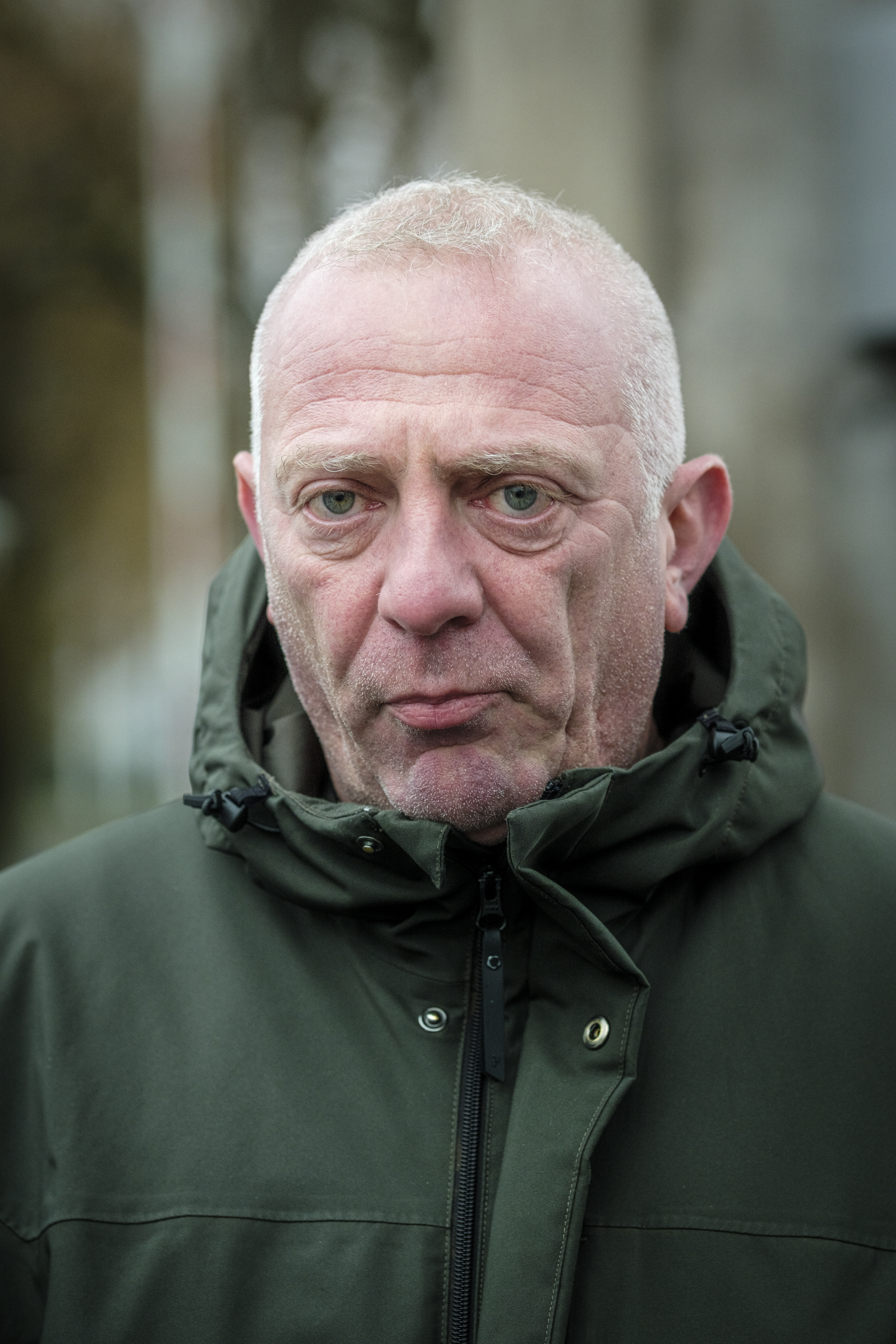 Suad Alomerovic med kort grått hår och allvarligt uttryck står utomhus iförd en mörkgrön jacka.