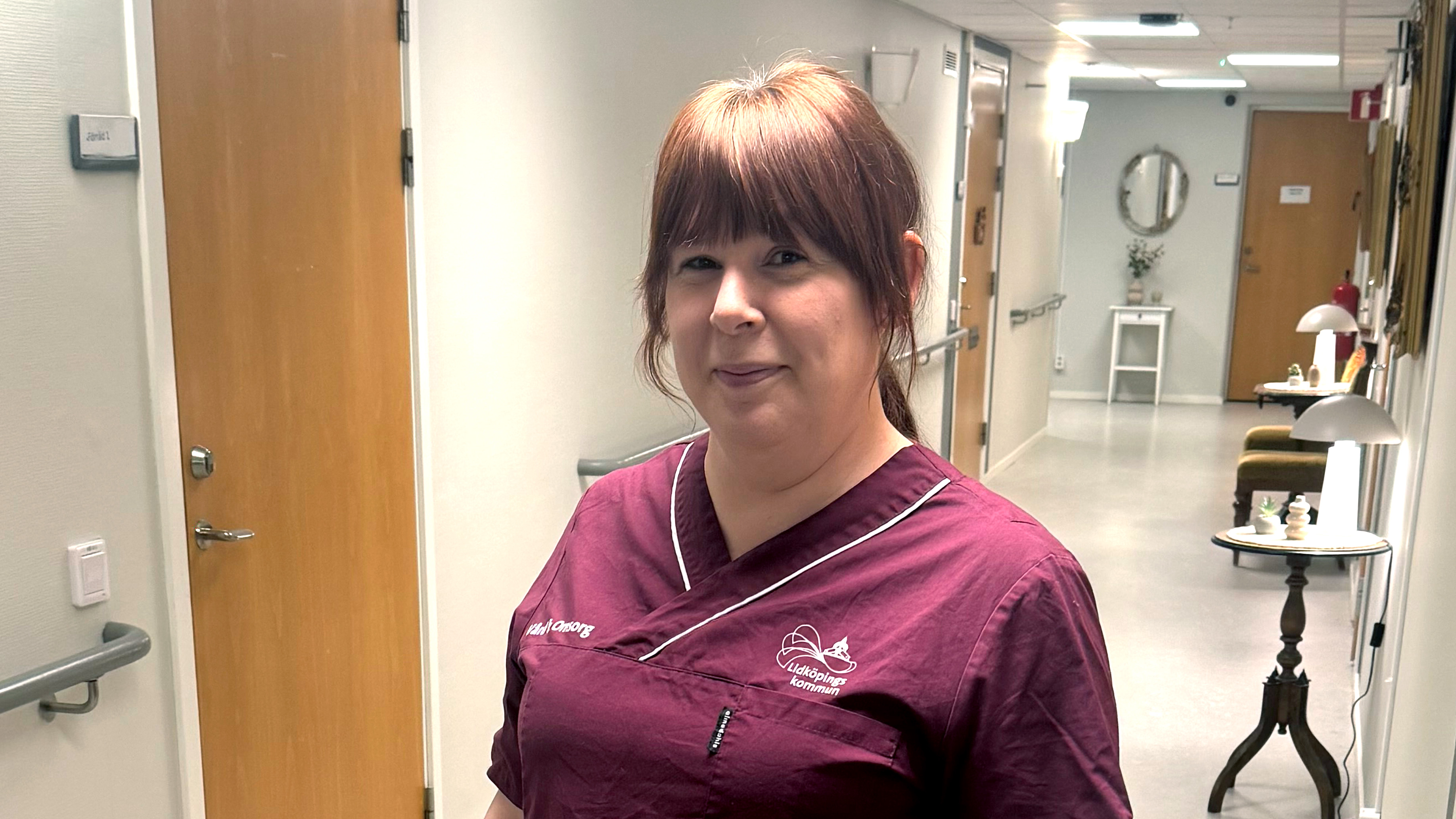 Tanja Olesen i vårdarbetskläder står i en korridor.