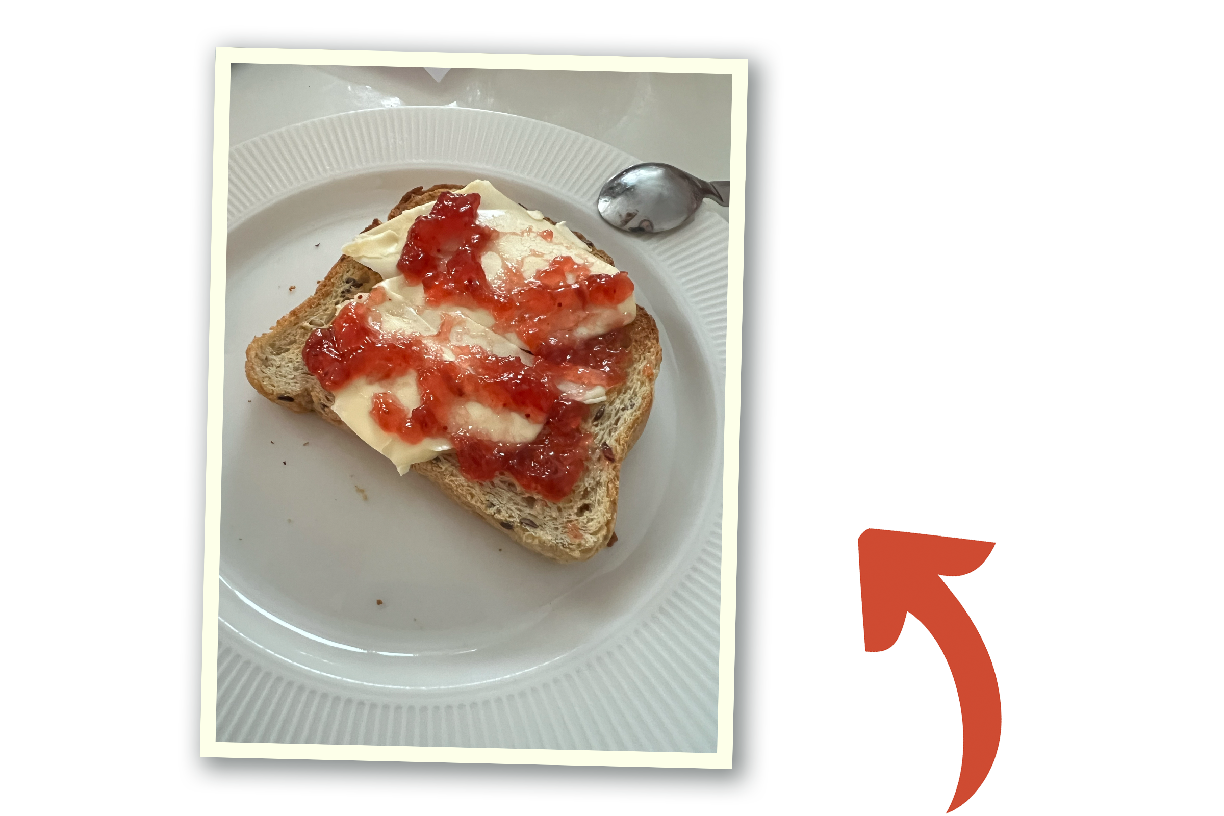 Bröd med ost och jordgubbssylt läggs på en vit tallrik. En röd pil pekar på bilden.