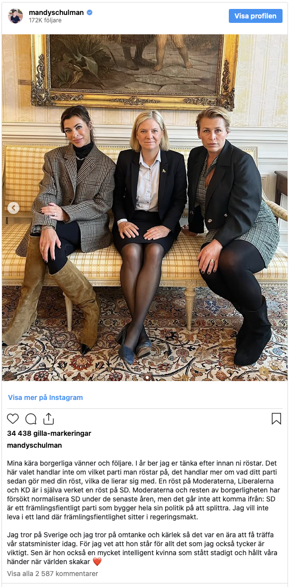 Tre kvinnor i arbetskläder sitter bredvid varandra på en soffa i ett formellt inomhusrum och tittar mot kameran.