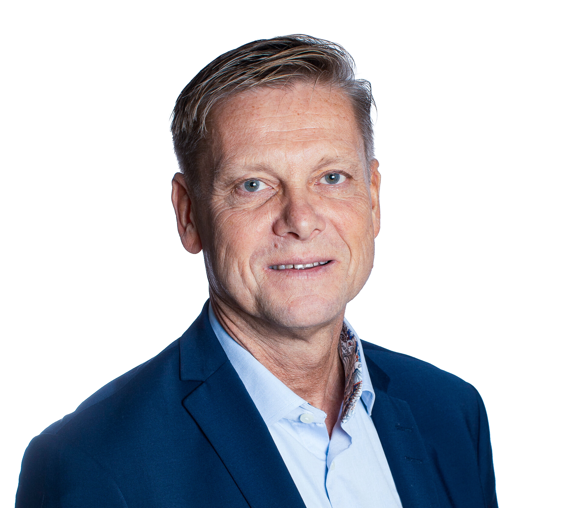 En man i blå kavaj och ljusblå skjorta står vänd mot kameran. Han har kort, ljusbrunt hår och står mot vit bakgrund.