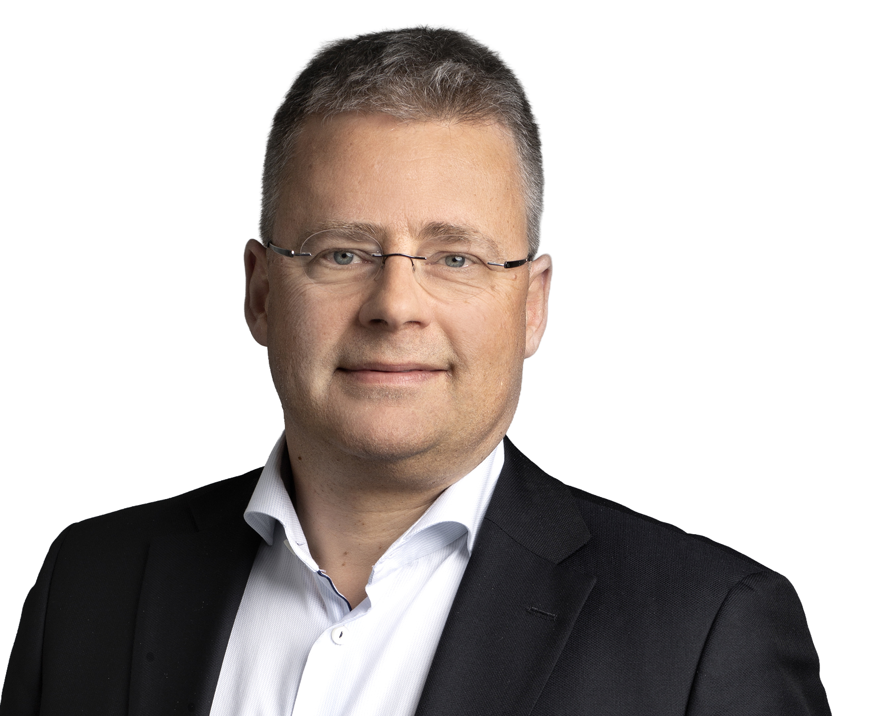 En medelålders man med kort grått hår och glasögon har på sig en vit skjorta och svart kavaj mot en ljus bakgrund.