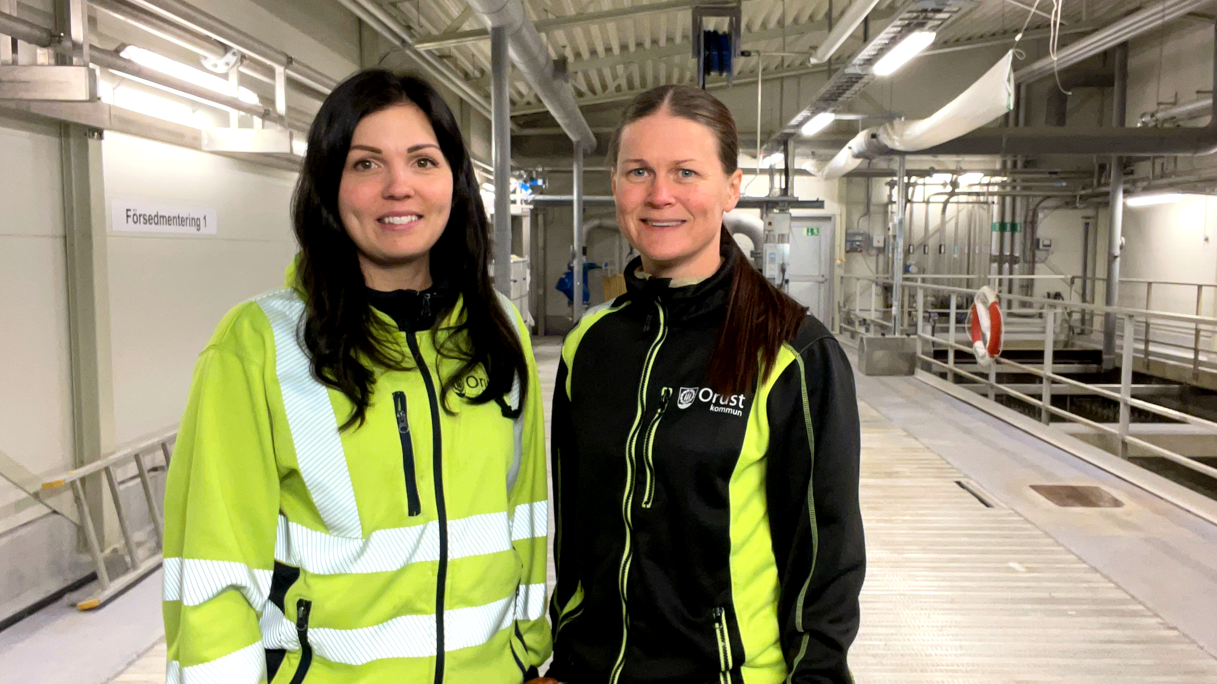 Julia Benktander och Emma Berglin i arbetskläder inomhus