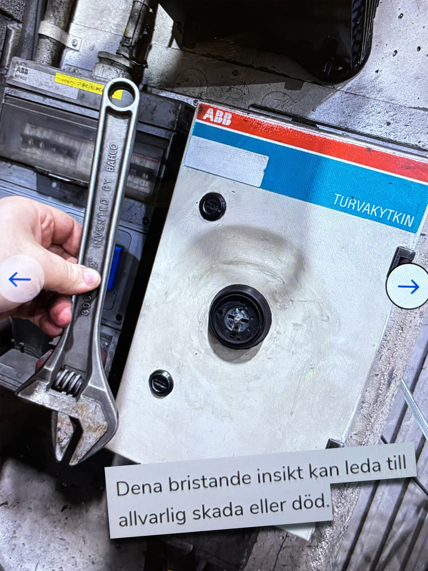 En person håller en skiftnyckel bredvid en elbrytare som är monterad på en vägg.