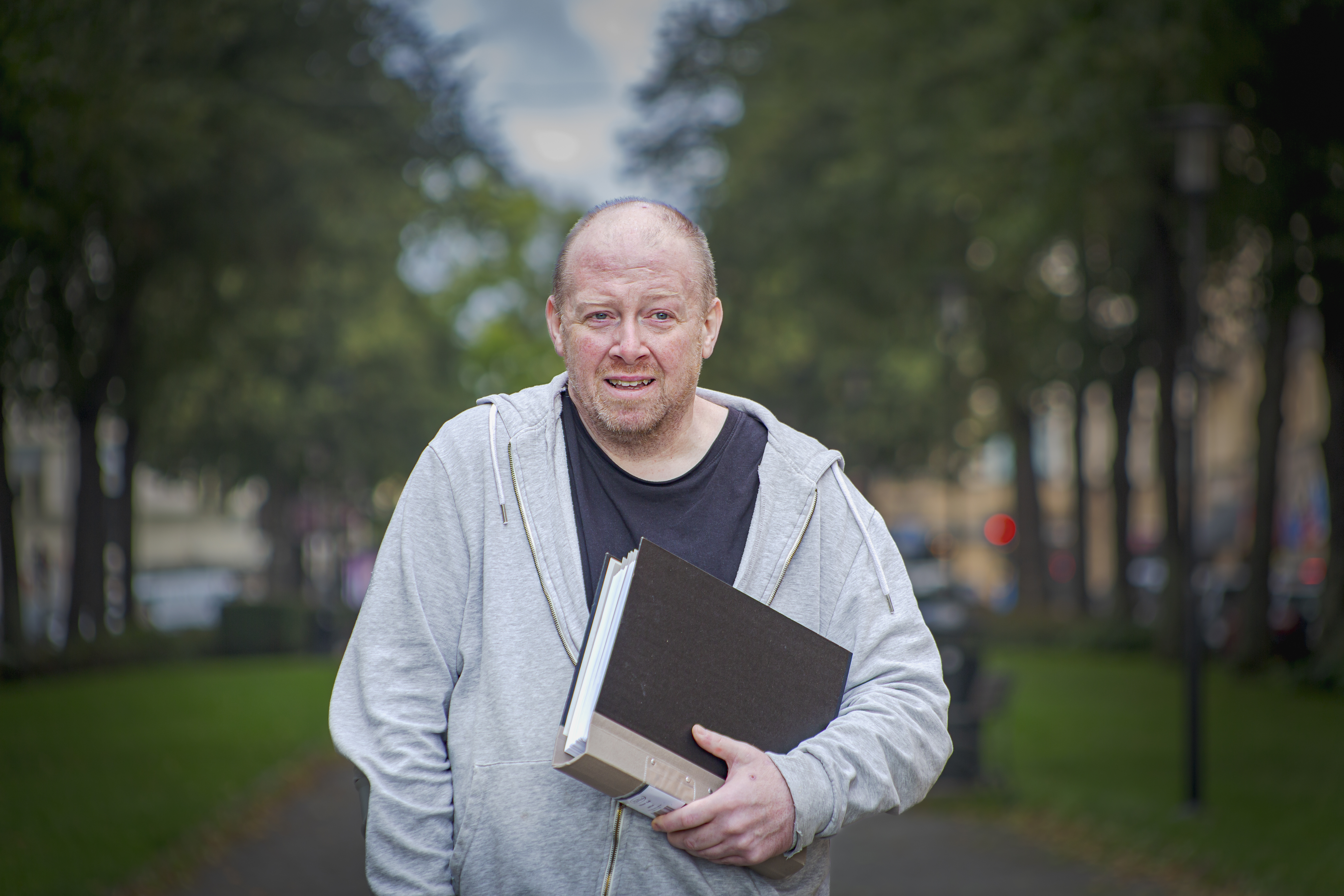 Daniel Pallin hållandes en pärm utomhus.