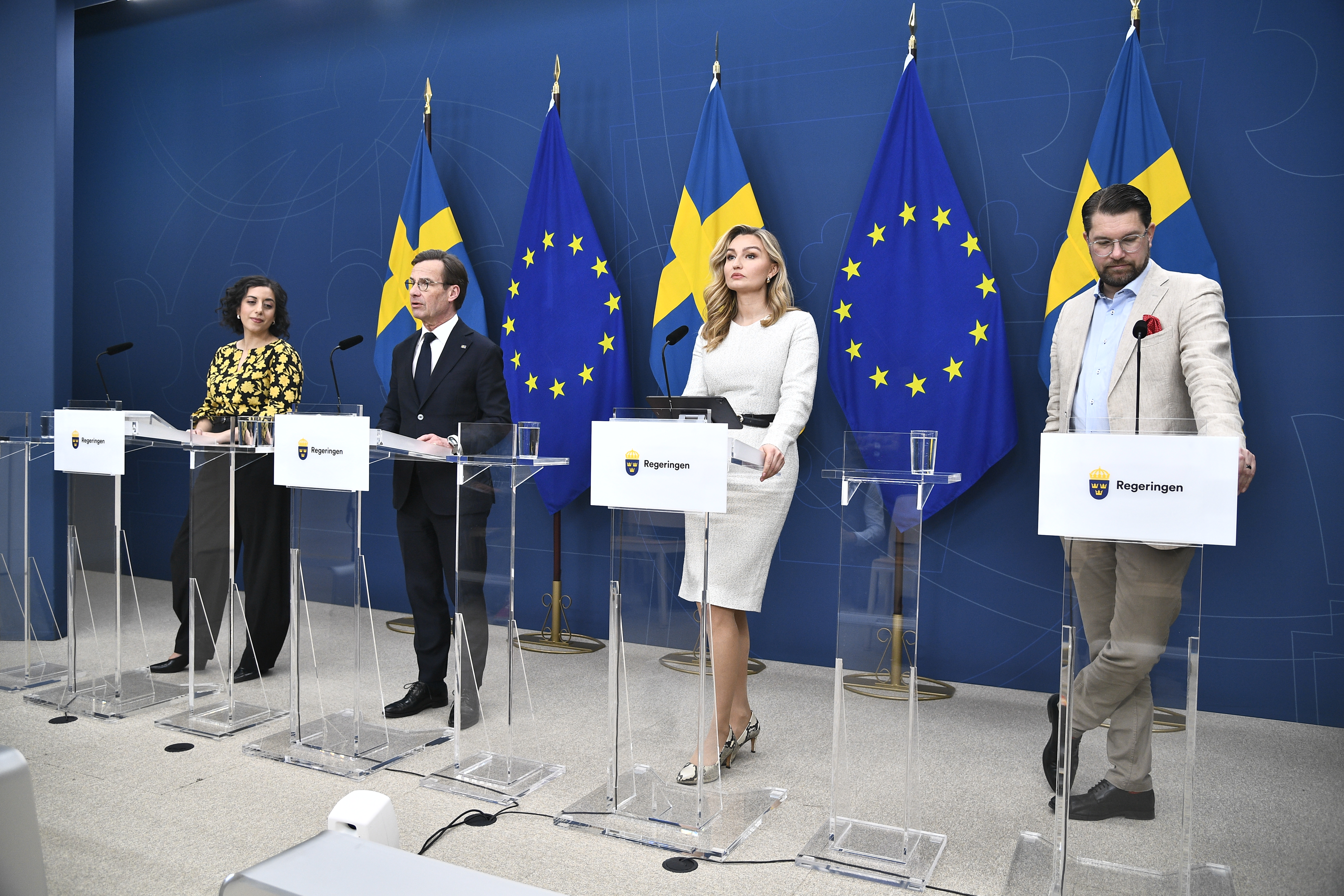 Fyra personer står på presskonferens i riksdagen.