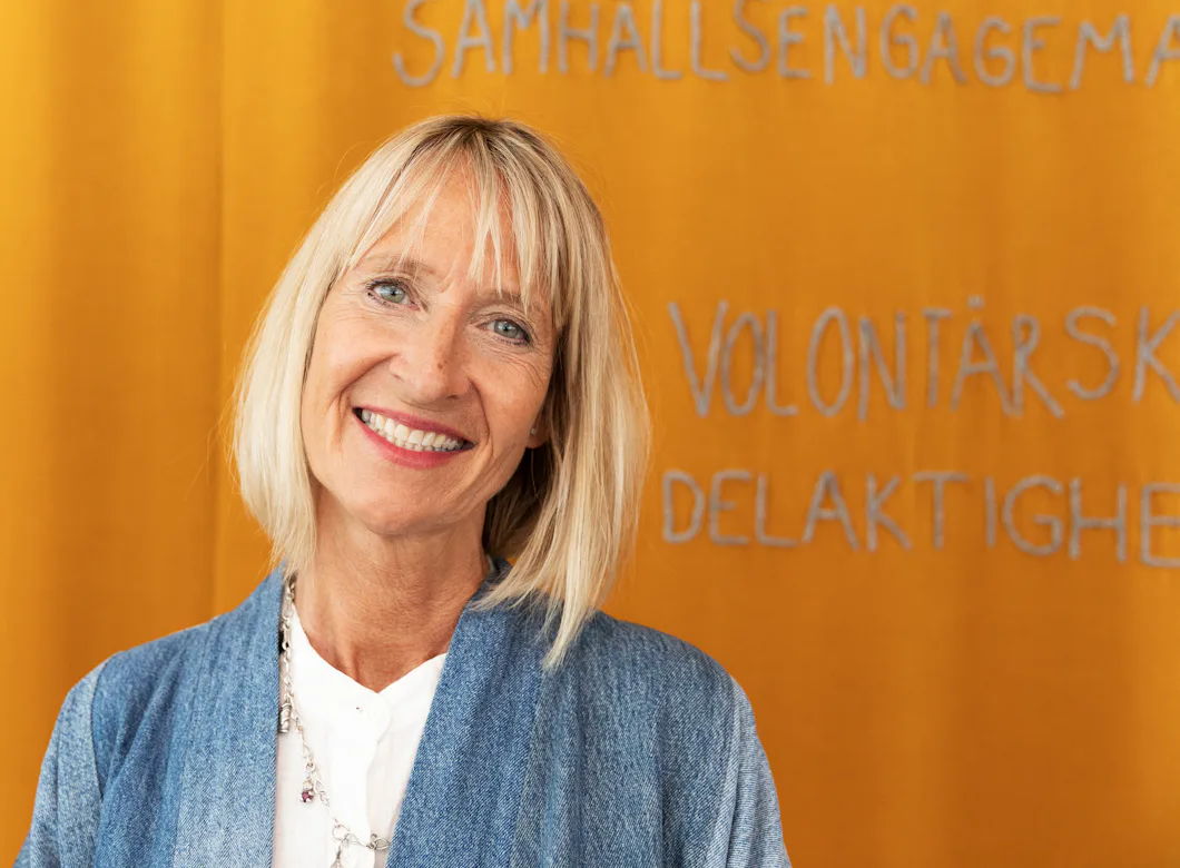 Åsa Paborn med blont hår står framför en gul bakgrund med svensk text.