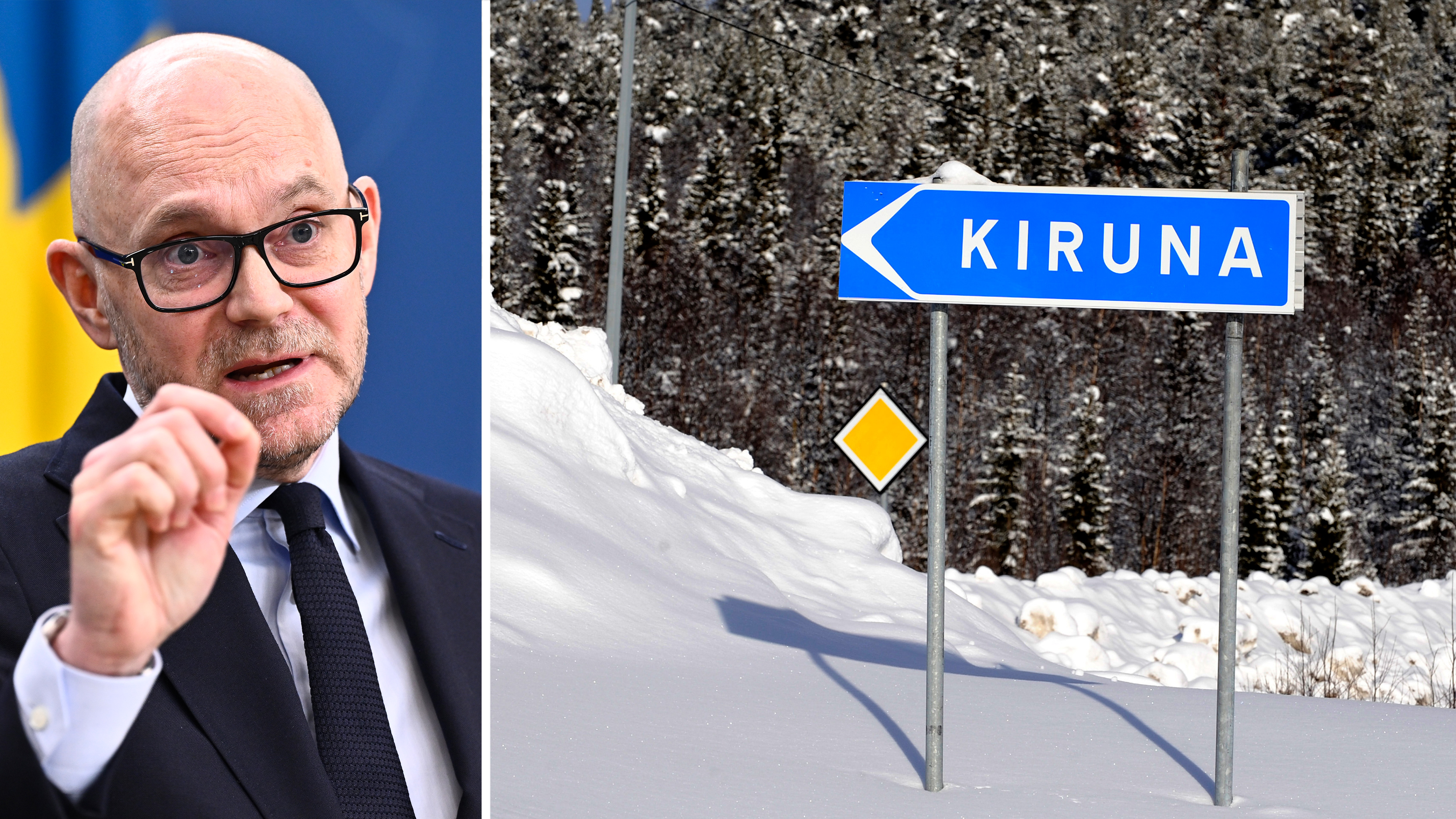 En man i kostym talar och gestikulerar bredvid en snöig vägskylt mot Kiruna, med träd i bakgrunden.
