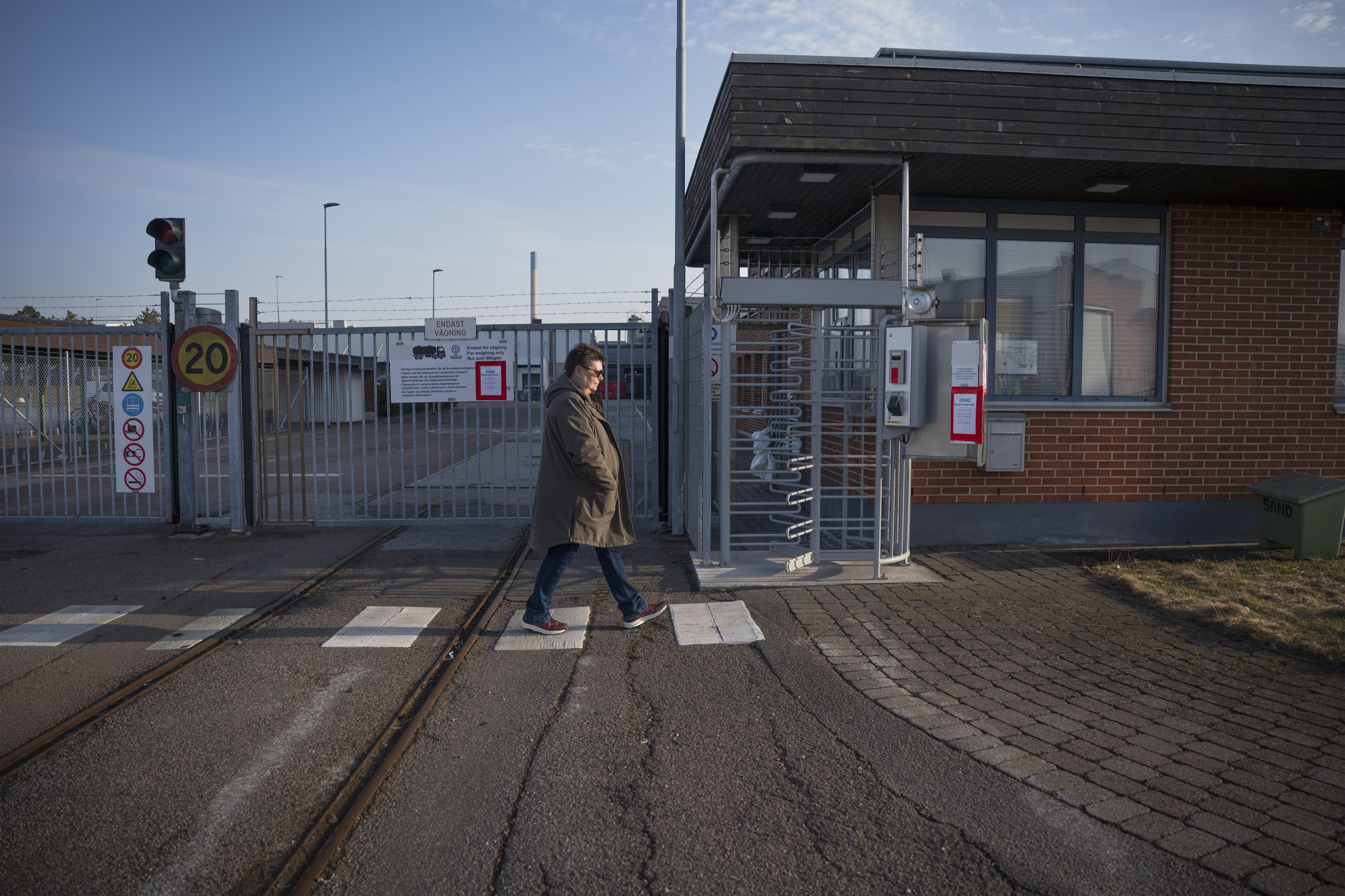 Miriam Håkansson går förbi en säkerhetsgrind med bommar och varningsskyltar.