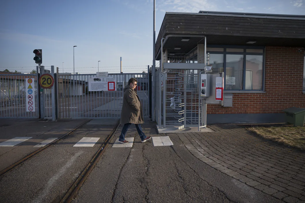 Miriam Håkansson går förbi en säkerhetsgrind med bommar och varningsskyltar.