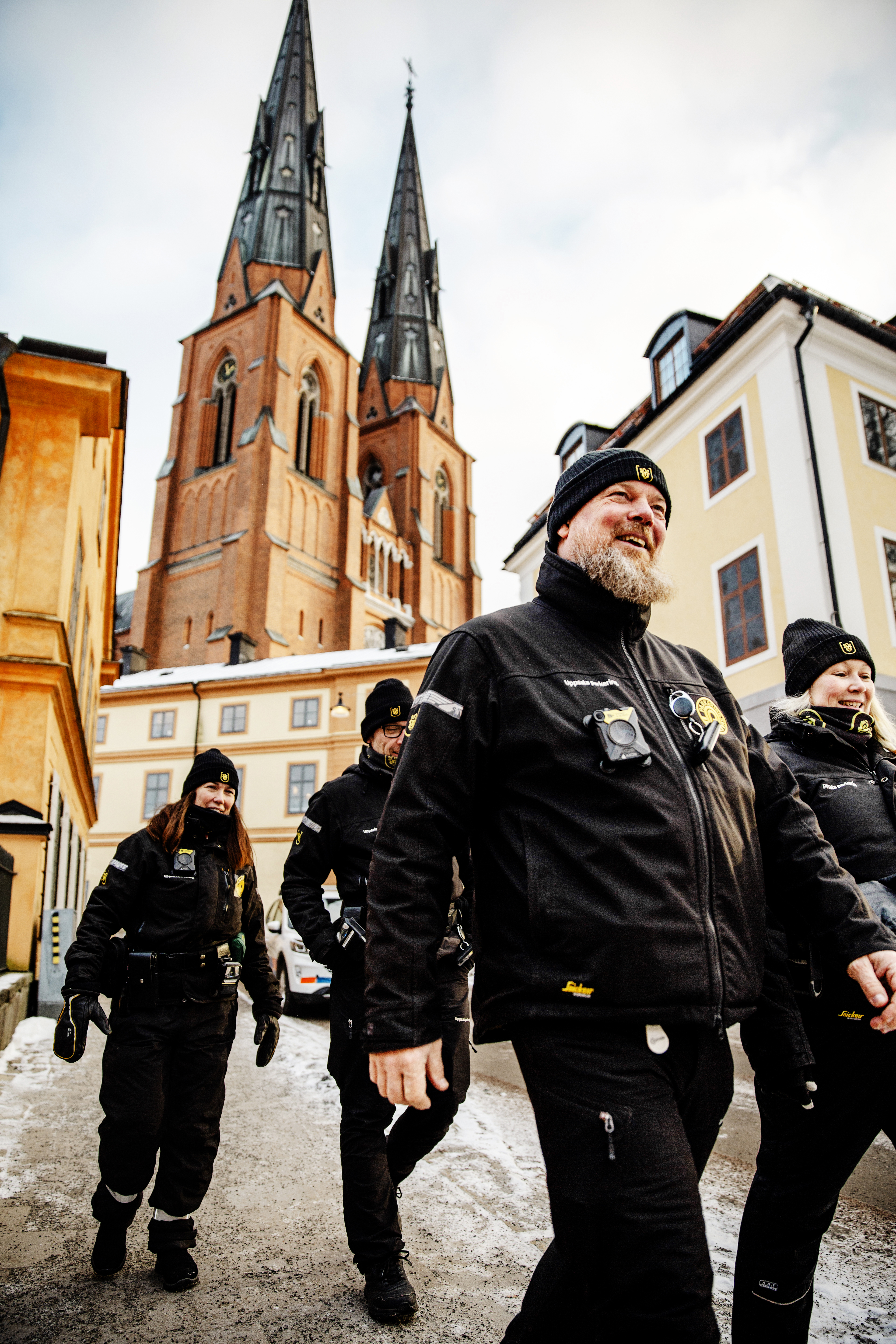 Parkeringsvakter går i grupp med Uppsala domkyrka i bakgrunden.