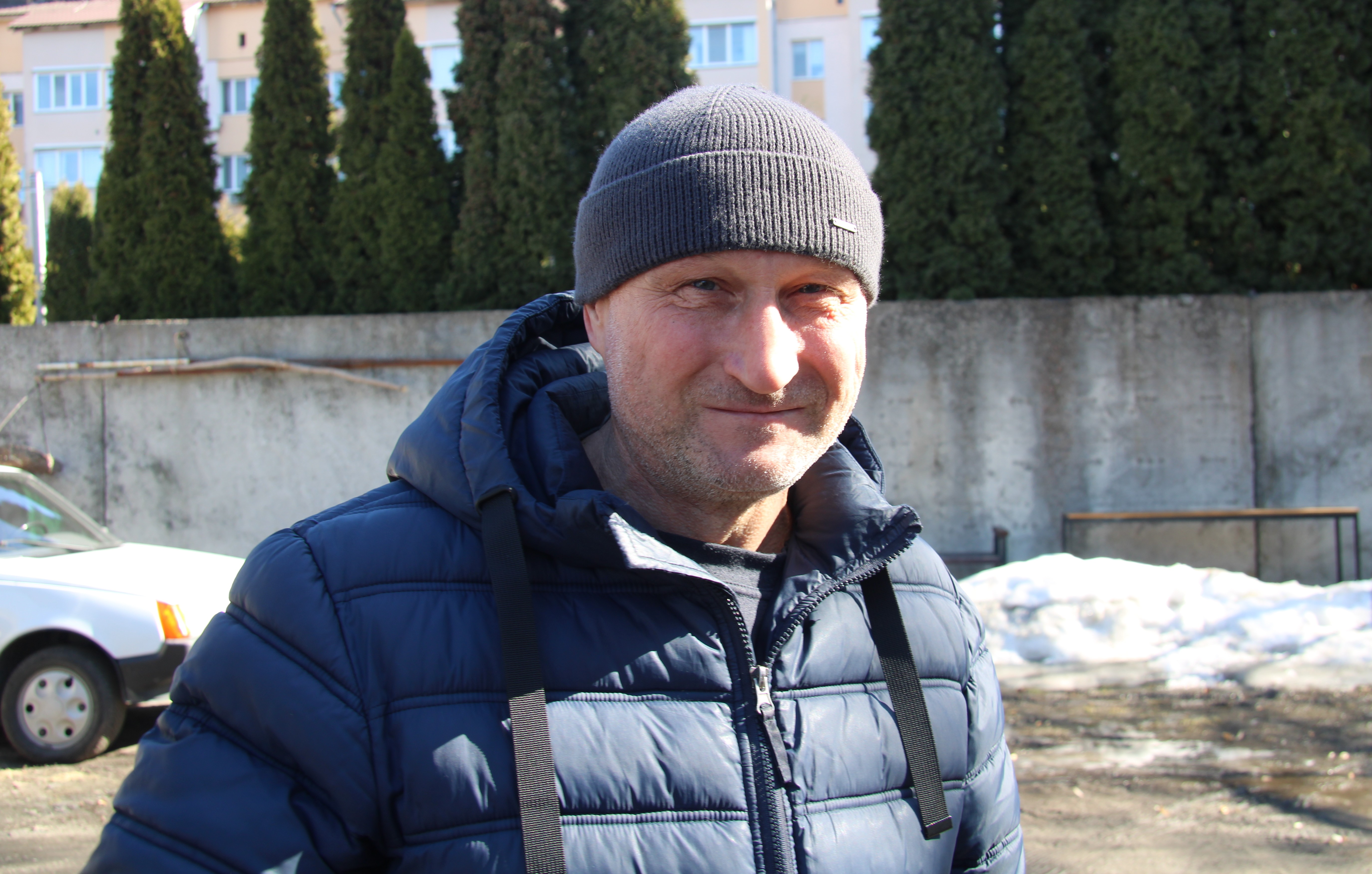 Viktor Yarovenko står utanför iförd en blå dunjacka och en grå hatt. Det är soligt och det är snö och träd i bakgrunden.