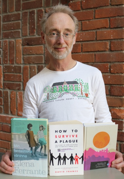 Jonas Ludvigsson visar upp några av de böcker som bokklubben läst. 