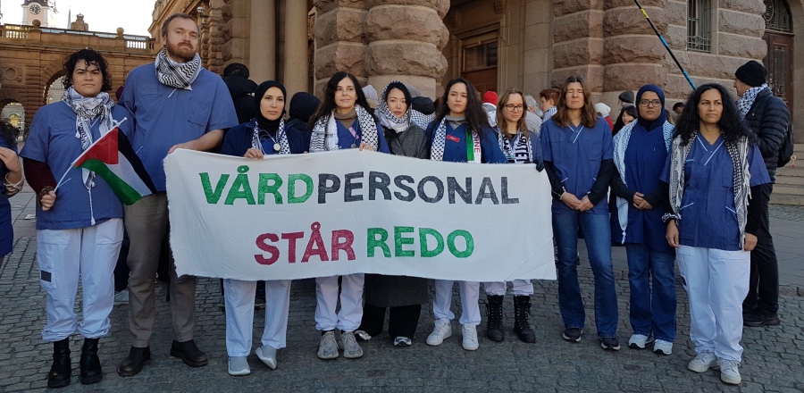 ”Vårdpersonal står redo” var budskapet på den banderoll som en grupp läkare, sjuksköterskor och annan vårdpersonal samlats kring utanför riksdagen inför interpellationsdebatten i en manifestationen på initiativ av Läkare mot rasism, Psykologer för Palestina och en rad andra organisationer. Foto: Stefan Karlsson
