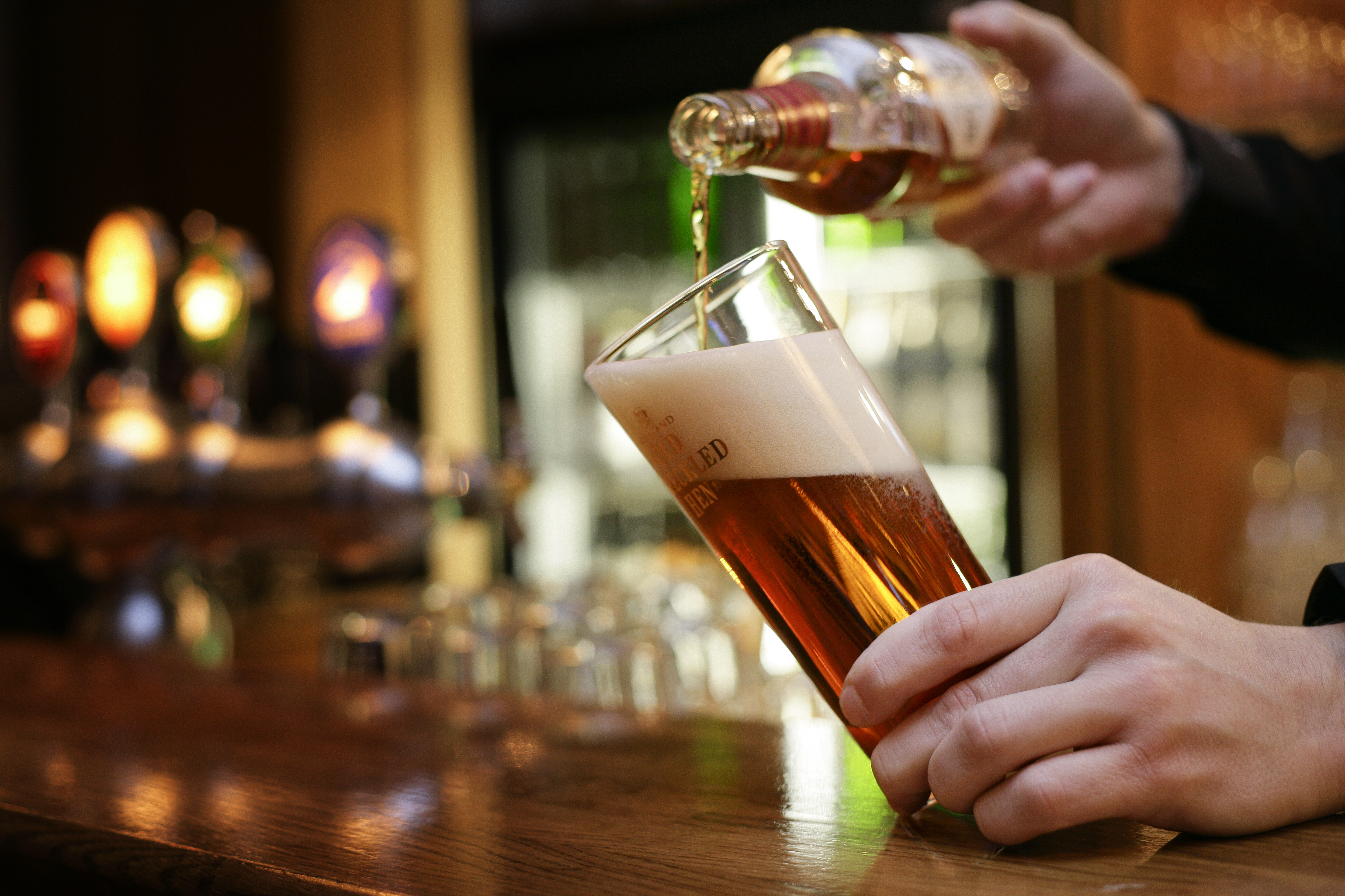 Bartender häller upp ett glas öl.