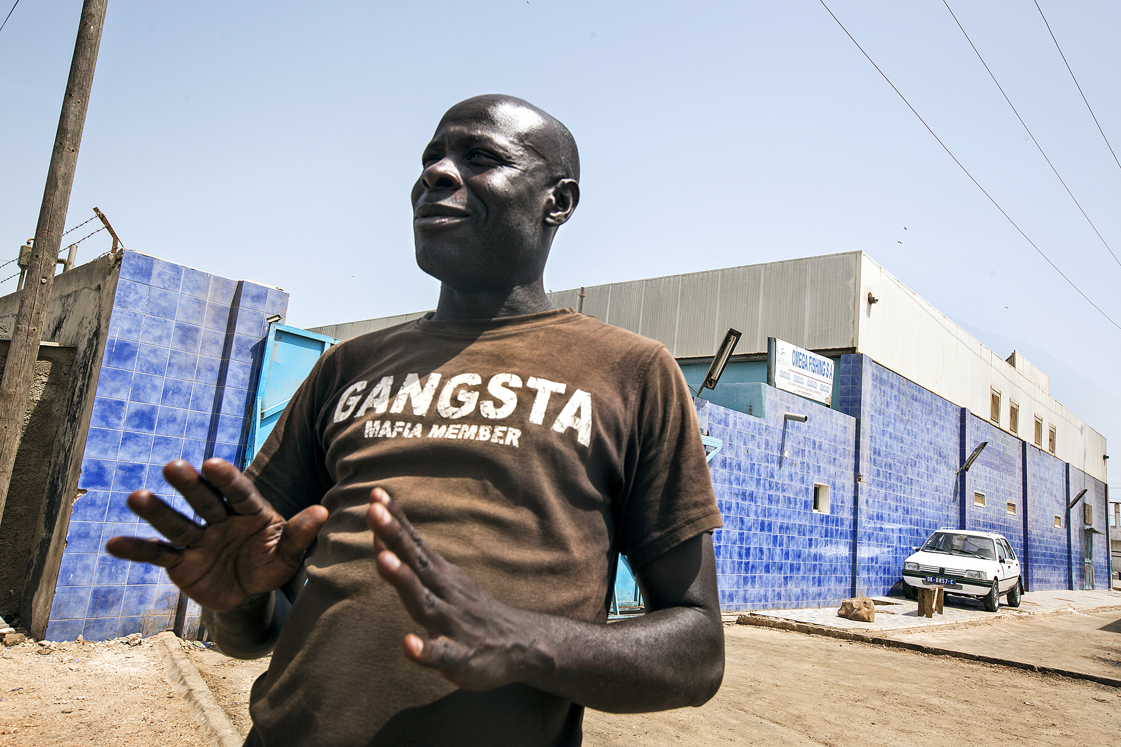 Vakten vid fiskmjölsfabriken i Joal vinkar avvärjande: här kommer inga journalister in.