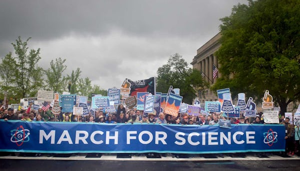 En stor uppslutning människor med plakat där det står "Science is good"och en stor banderoll där det står "March for science".