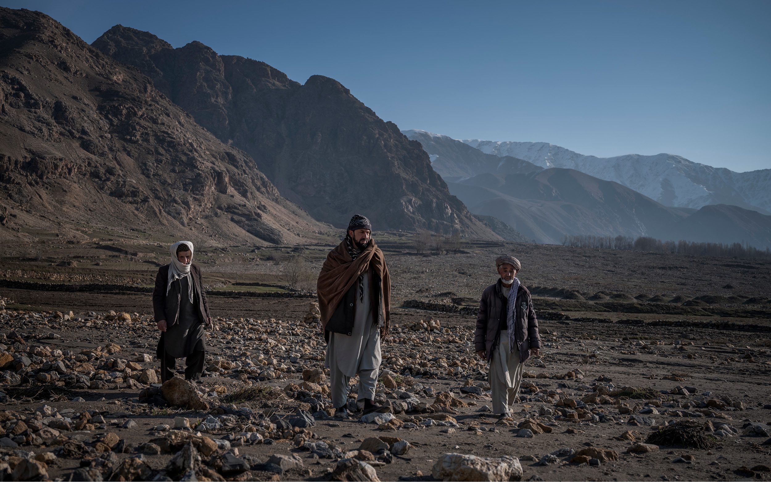 Tre män på ett fält.