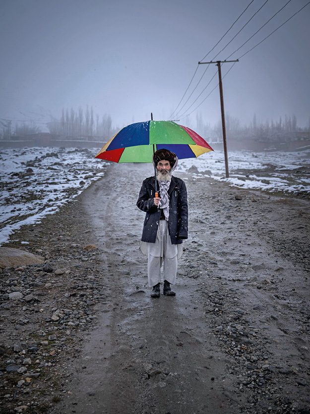 Men med paraply i regnbågens färger.