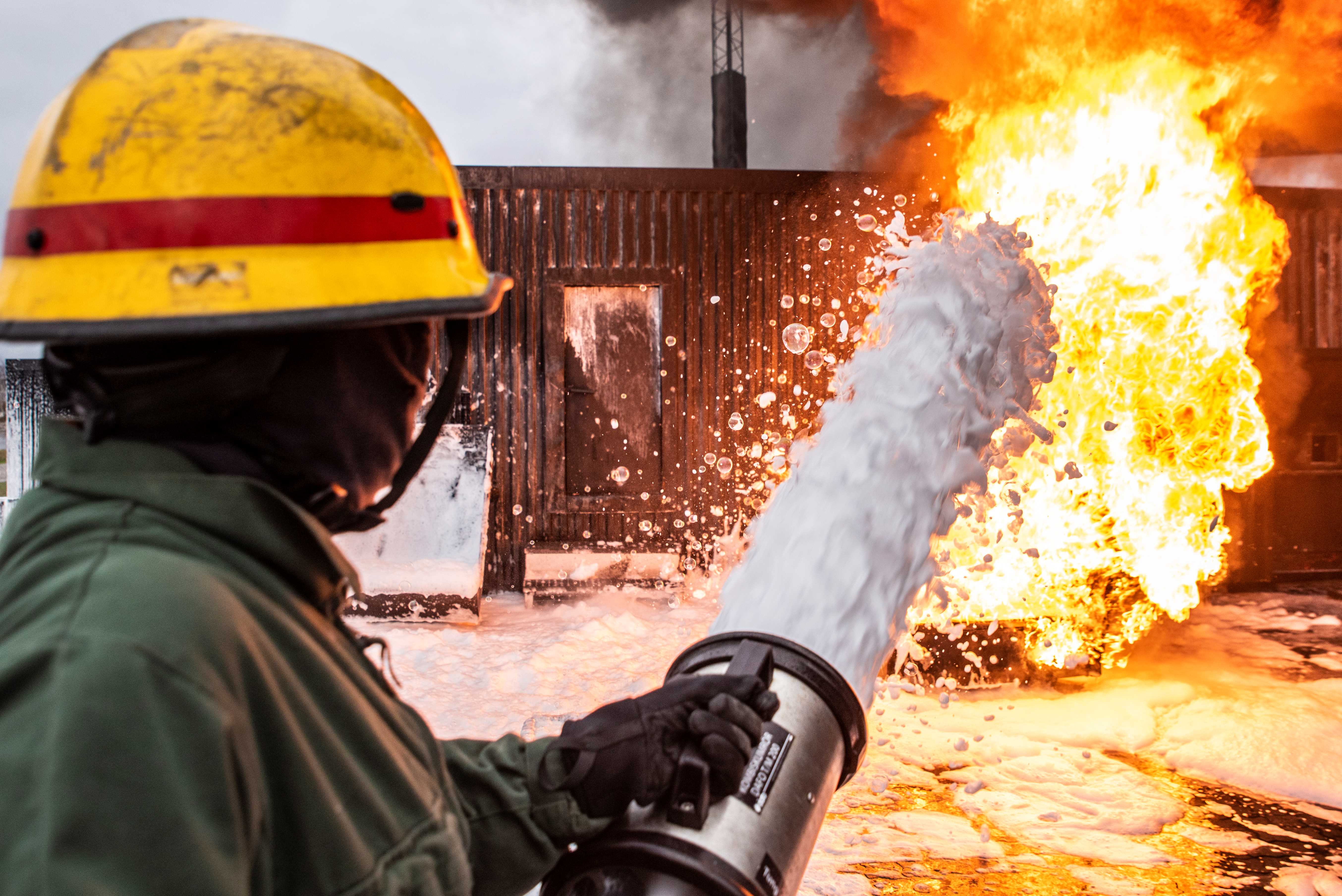 Brandman släcker eld med skum.