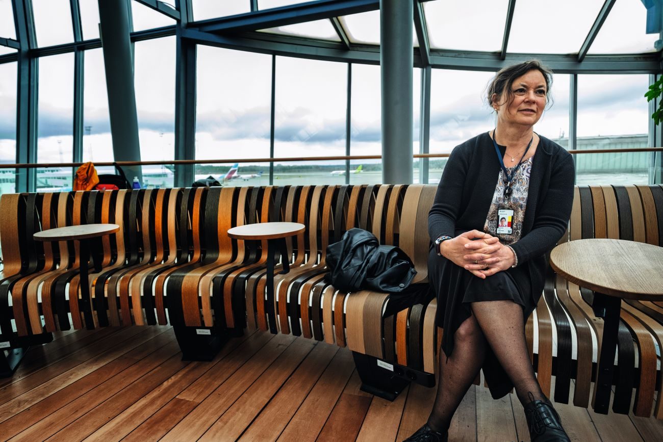 Dam på bänk i terminalbyggnad.