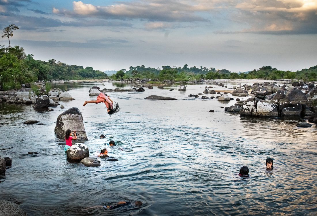 Barn som hoppar i vatten.