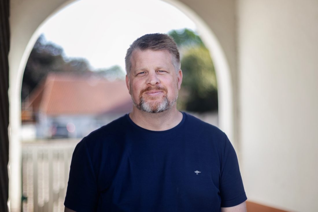 Man med skägg i t-shirt.