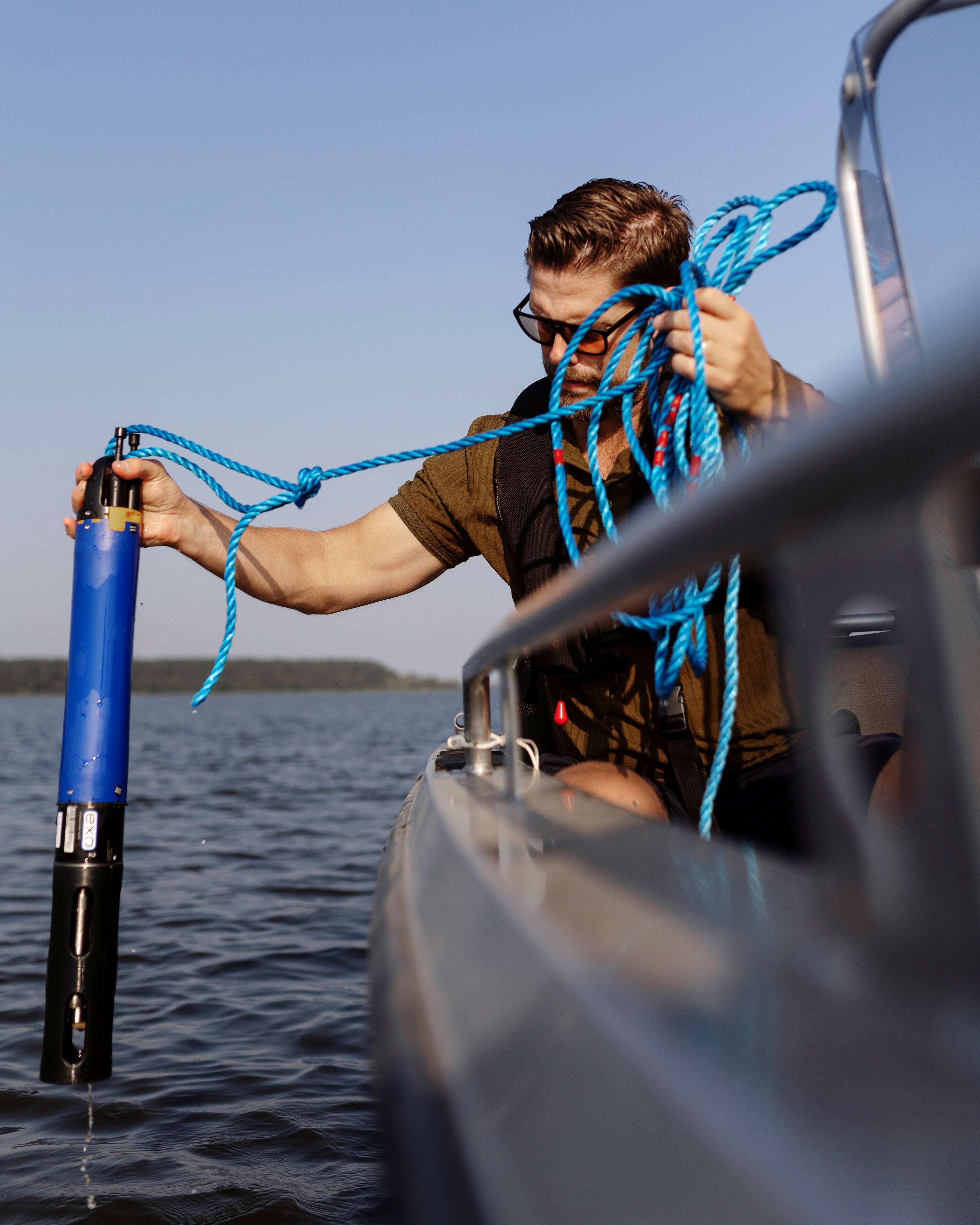 Man i båt som tar prover i sjö.