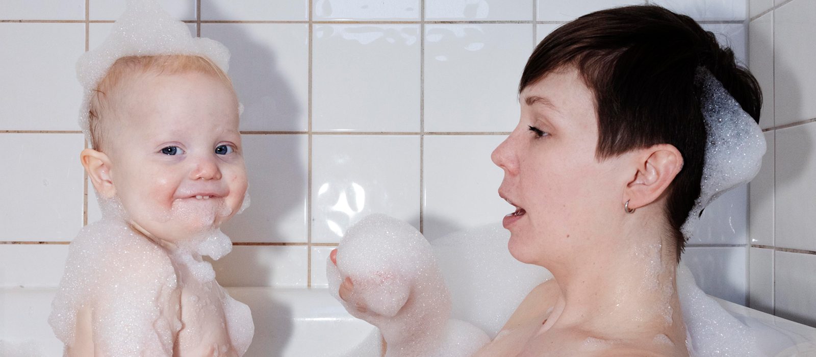 Barn och mamma i badkar med badskum