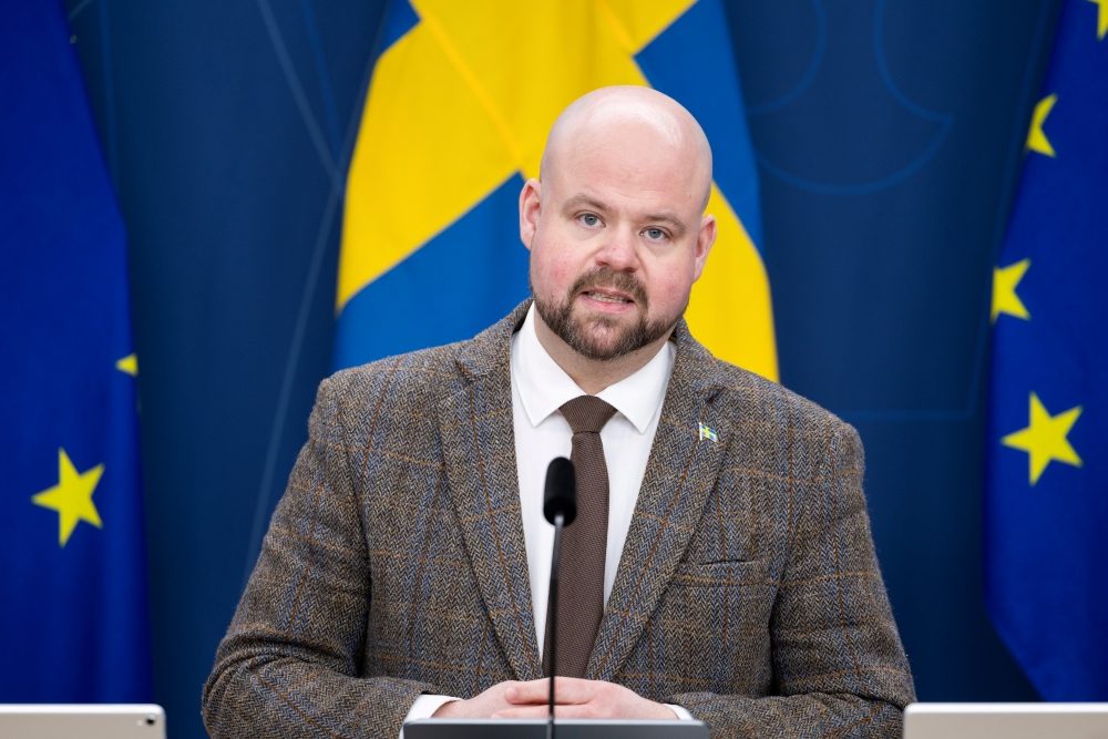 Man i kostym med svensk flagga