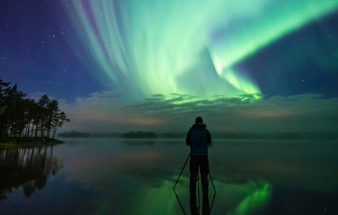 Skridskoåkare i norrsken.