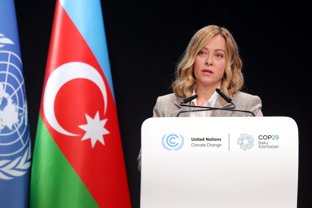 Kvinna i talarstol vid flagga