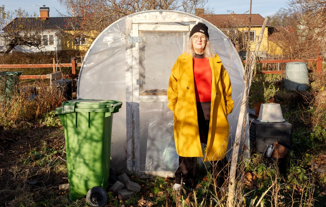 Kvinna framför växthus.