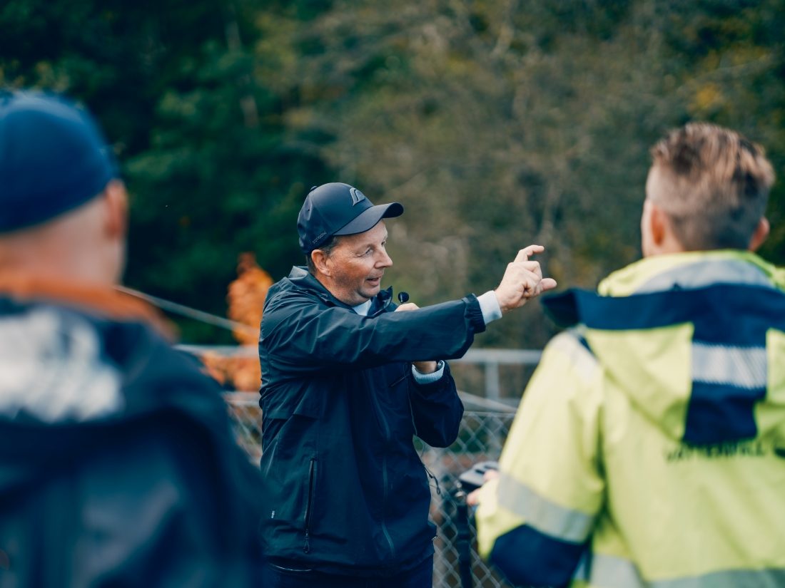 Man i keps pratar och gestikulerar. 