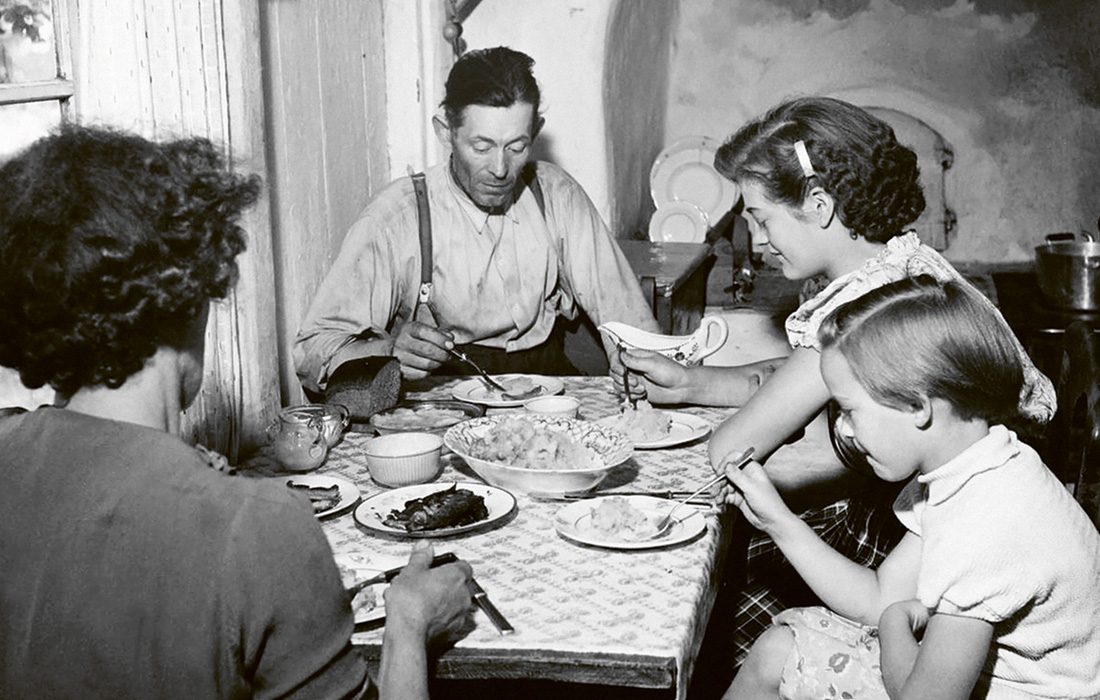 Familj äter middag vid bord.