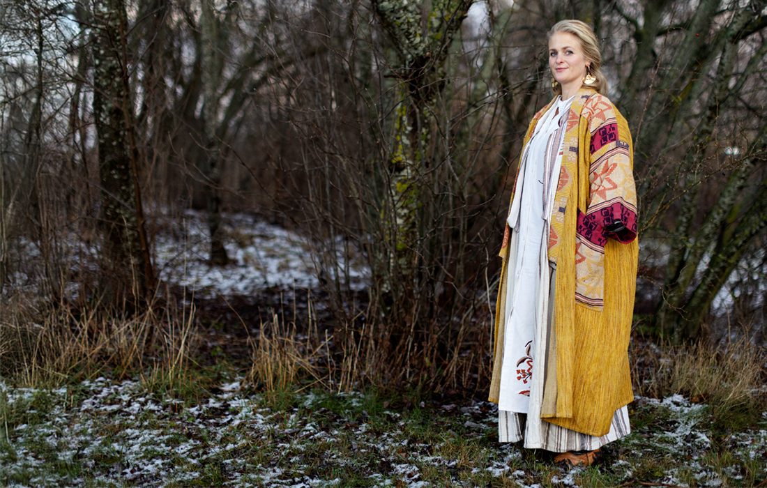 Sofi Svensson står i kaftan i trädgård