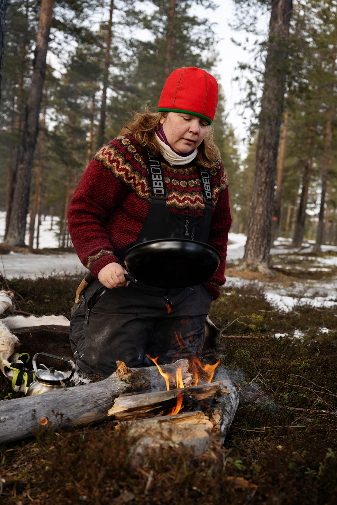 Person lagar palt över öppen eld.