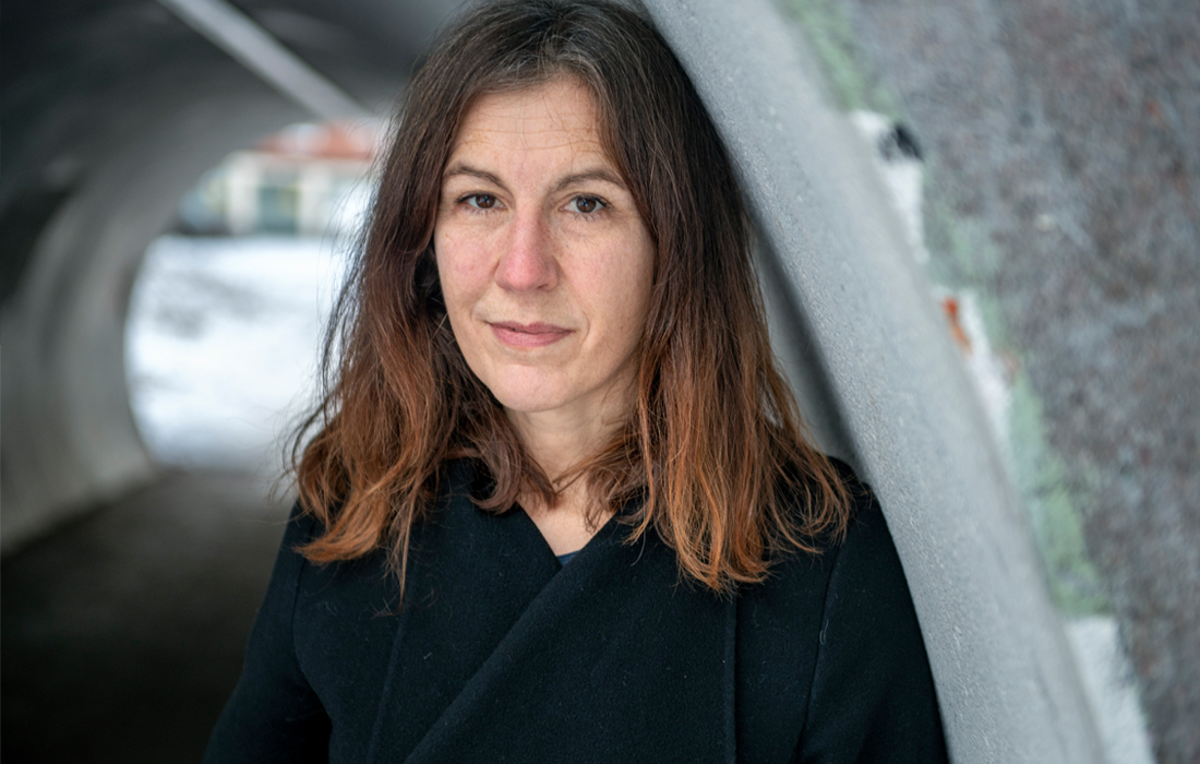 Porträttbild på Lisa Röstlund framför en gångtunnel.
