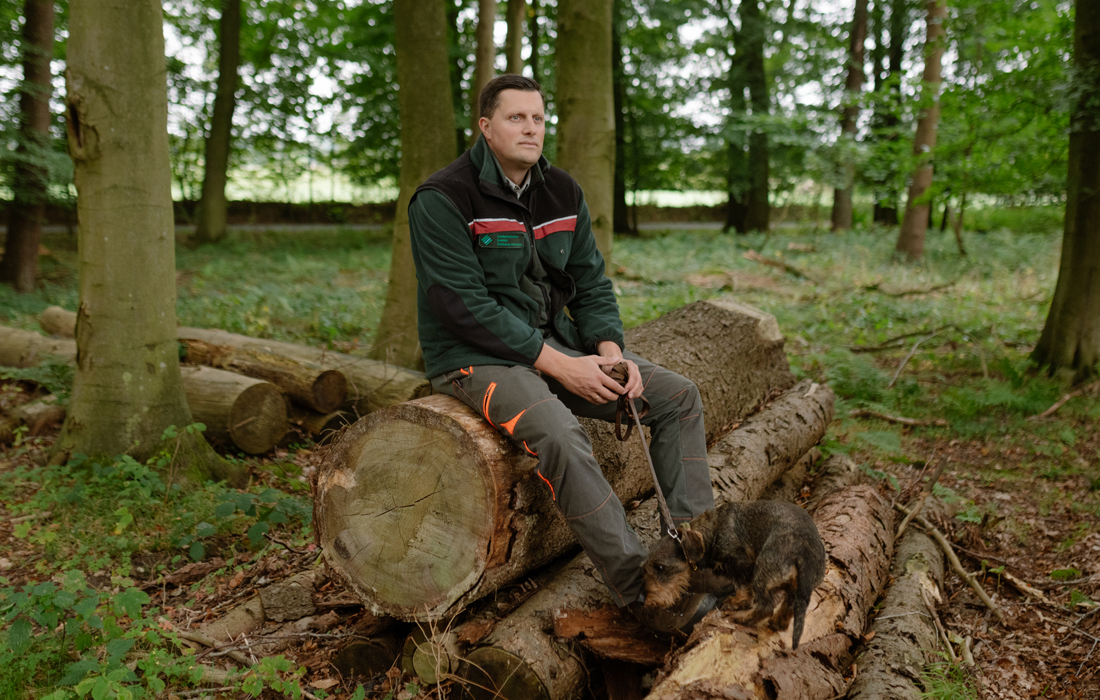 Peer Rosenhagen sitter på en stock.
