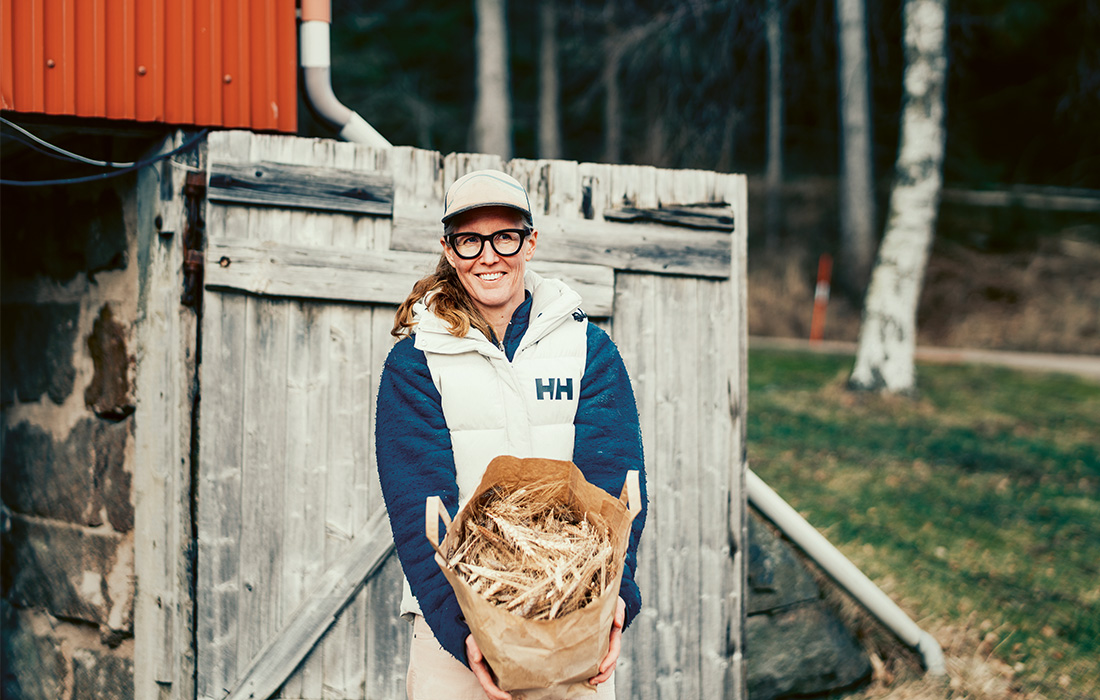 kvinna håller i säck med vete.