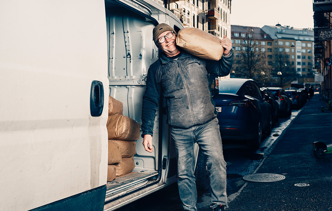 Man håller upp en säck utanför en skåpbil.